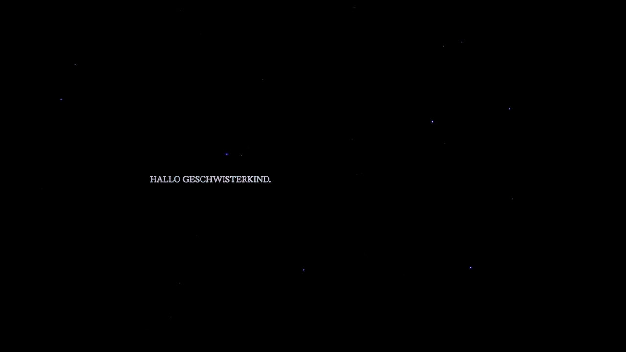 Still: a few faint stars scattered across black space, with a small line of overlaid text among them.