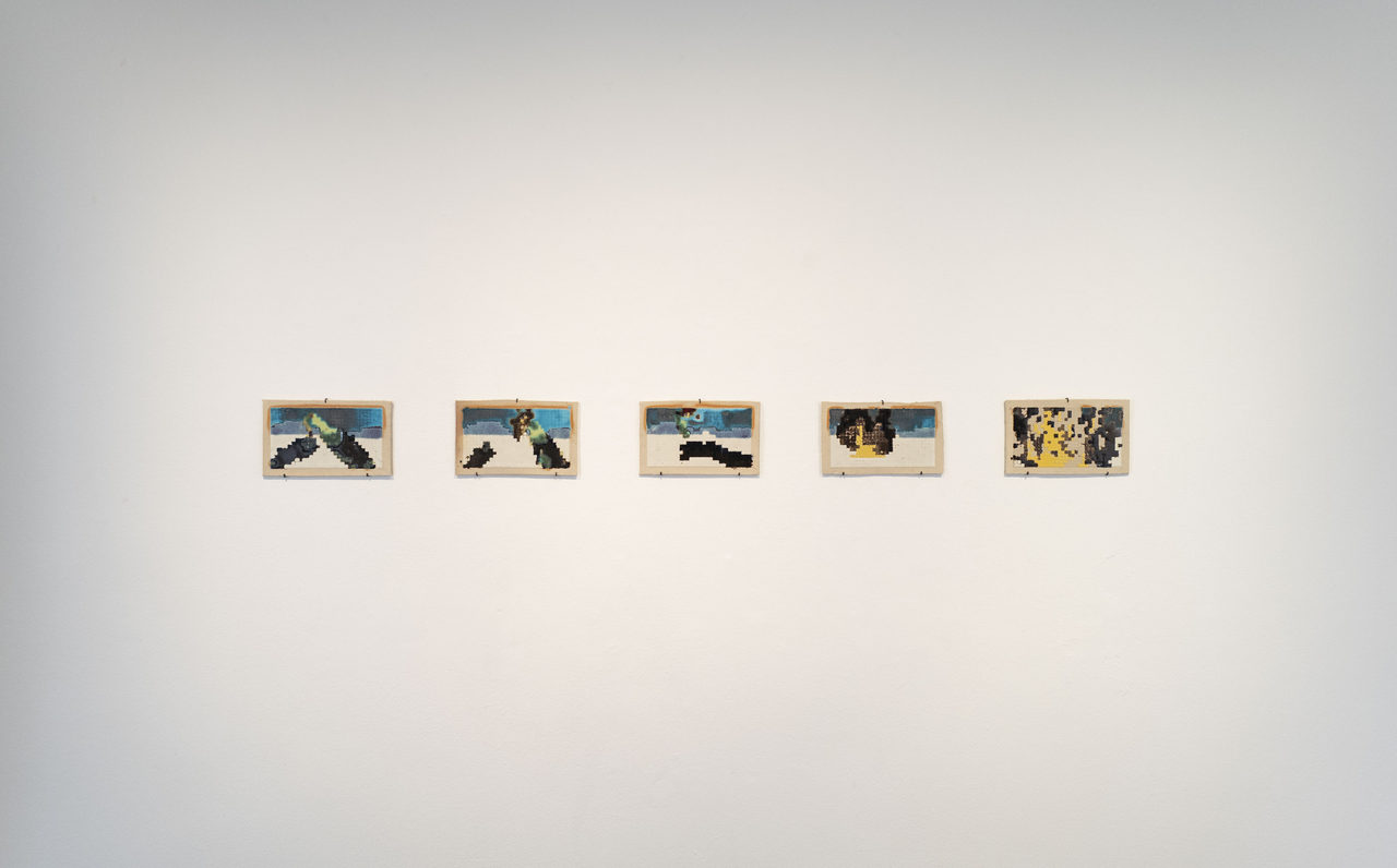 Five small ceramic panels in pale wooden frames hang evenly spaced on a white wall; each carries a coarse, pixel-like image in blue, green, black and yellow, together reading as a sequence of frames.
