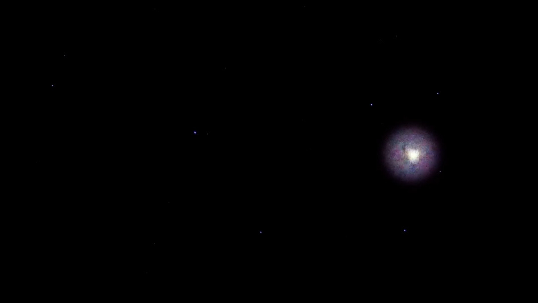 Still: a tiny, brightly glowing celestial body with a halo in otherwise black space.